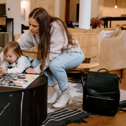 Stylish parent using Florence Black Nappy Bag while out with bab