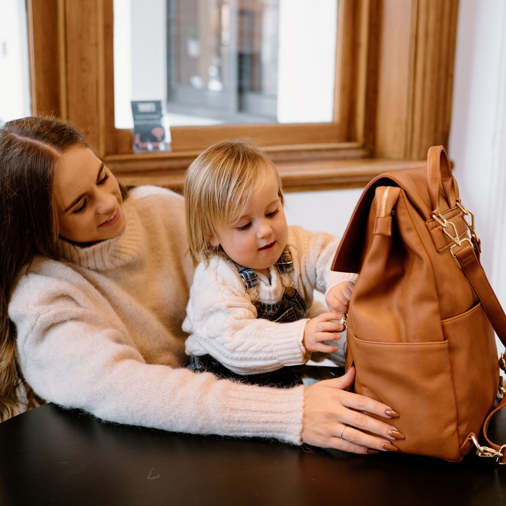 Busy parent with Florence Tan Nappy Bag during day out with baby
