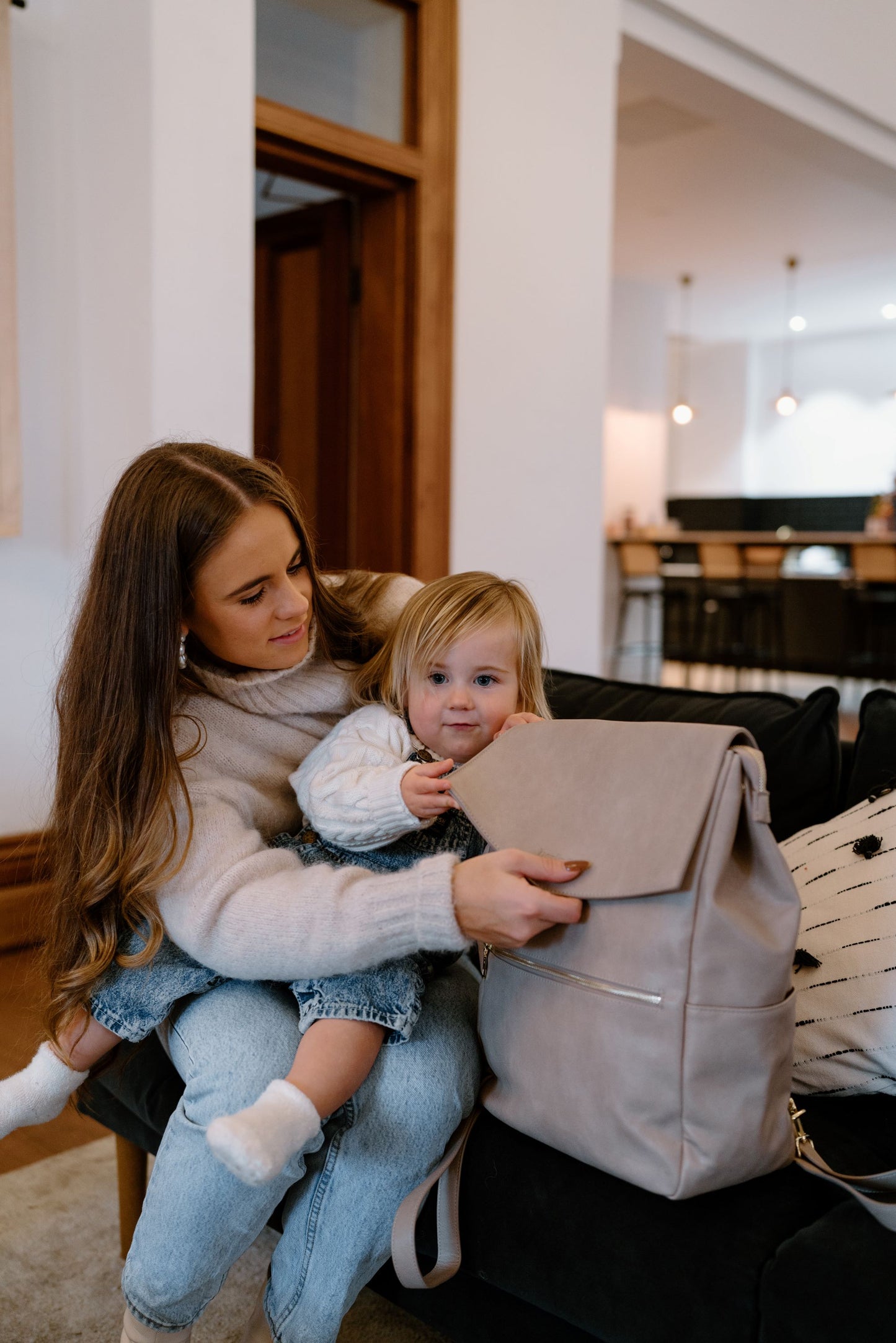 Parent using Florence Taupe Nappy Bag while on the go with baby