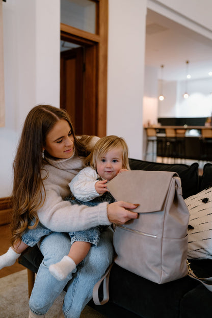 Parent using Florence Taupe Nappy Bag while on the go with baby
