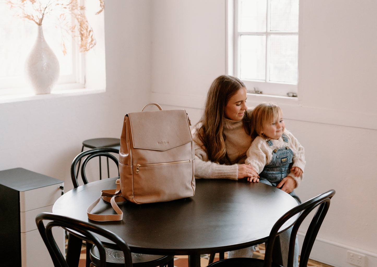 Parent using Florence Taupe Nappy Bag while on the go with baby