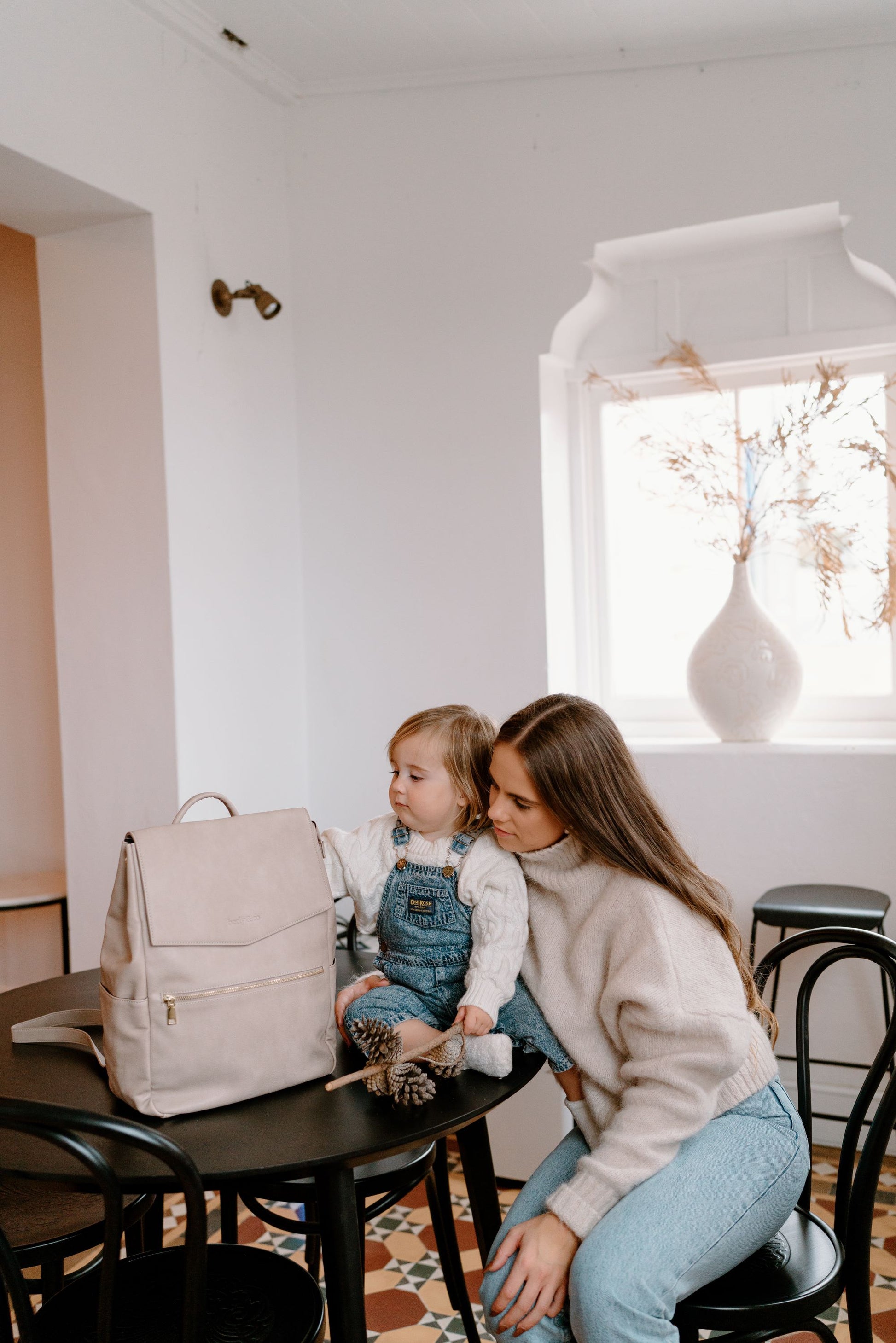 Parent using Florence Taupe Nappy Bag while on the go with baby