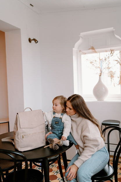 Parent using Florence Taupe Nappy Bag while on the go with baby