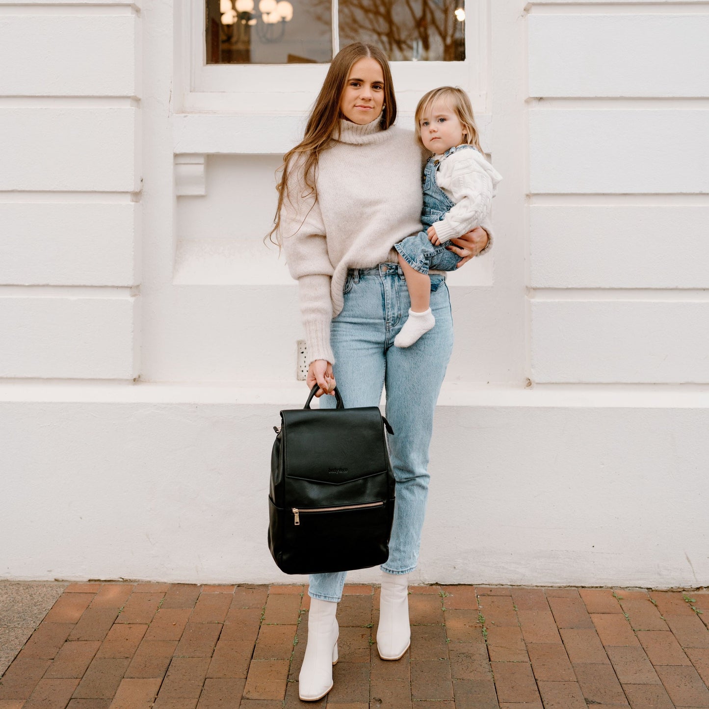 Stylish parent using Florence Black Nappy Bag while out with baby