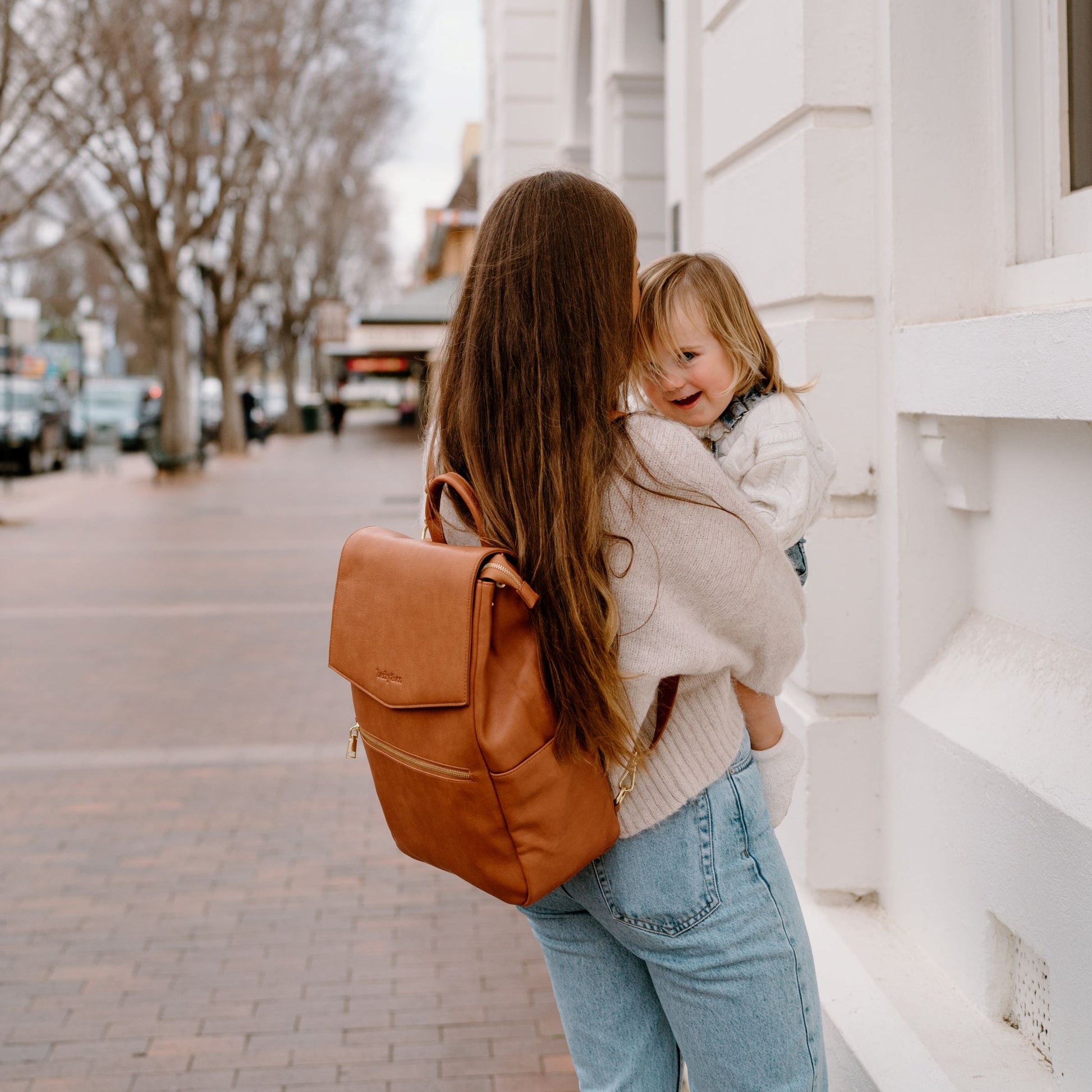 Parent wearing Florence Tan Nappy Backpack showing comfortable fit for everyday use