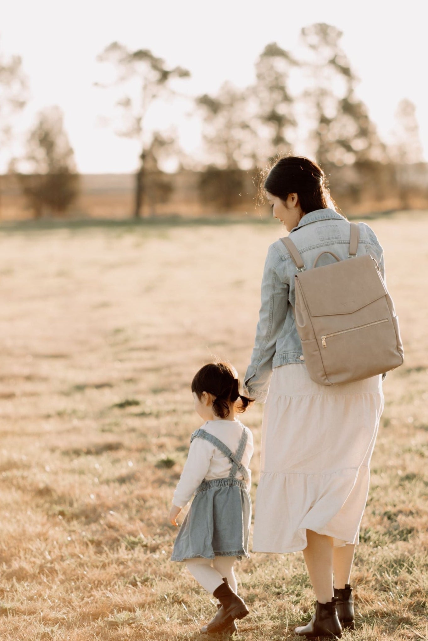 Parent using Florence Taupe Nappy Bag while on the go with baby